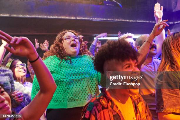 group of people having fun at a music venue. - crowd excitement stock pictures, royalty-free photos & images