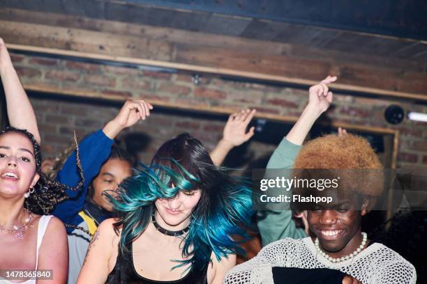 group of people enjoying an evening out at a music venue. - gig stock pictures, royalty-free photos & images