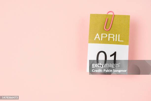 calendar page for april 1st with a paper clip against a light gray background. - april fool photos et images de collection
