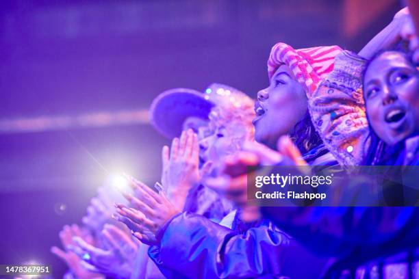 group of people enjoying an evening out at a music venue. - music festival dancing stock pictures, royalty-free photos & images