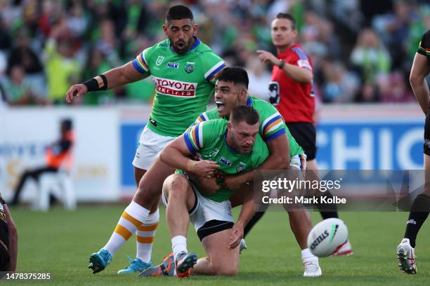 Emre Gulerand Matthew Timoko of the Raiders celebrate with Elliot Whitehead of the Raiders after he scored a try during the round five NRL match...