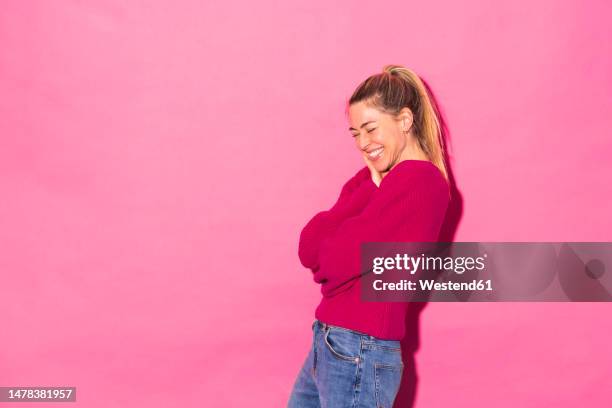 happy woman against pink background - coloured background lachen stock-fotos und bilder
