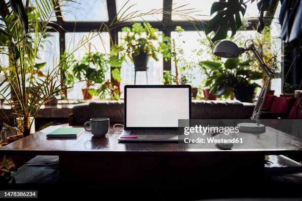 laptop with blank screen on desk at loft office - abandoned houses photos et images de collection