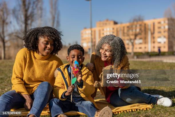 happy multi-generation family spending leisure time in park - light vivid children senior young focus foto e immagini stock