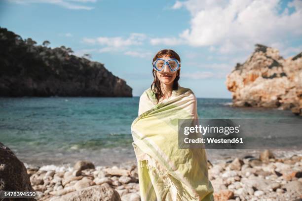 woman wrapped in blanket after swimming at beach - envuelto en una toalla fotografías e imágenes de stock