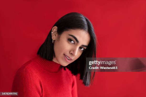 smiling beautiful woman against red background - portrait femme fond rouge adulte photos et images de collection