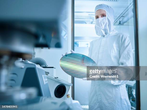 engineer holding wafer chip in laboratory - silicium photos et images de collection