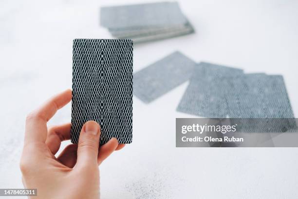 female hand holding tarot card. - prophet stock pictures, royalty-free photos & images