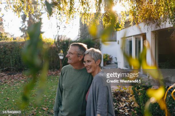 happy senior couple in garden looking around - looking around stock pictures, royalty-free photos & images