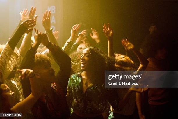 group of people dancing at a music venue. - party hat stock-fotos und bilder