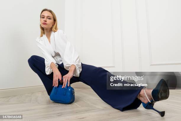 blonde young model wearing autumn concept clothes. - blue trousers stock pictures, royalty-free photos & images