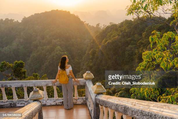 woman walking on stairs in wat tham sua in krabi at sunset - wonderlust stockfoto's en -beelden