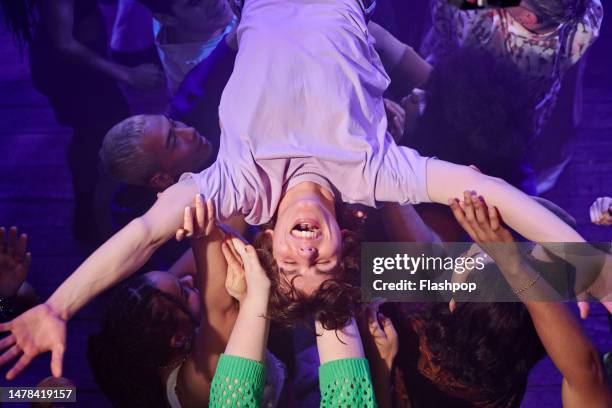 people enjoying an evening out at a music venue. - stage diving stock-fotos und bilder