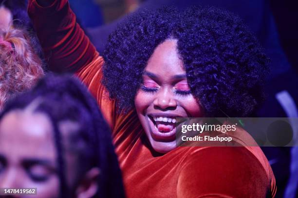 close-up of woman dancing at a music venue. - music festival dancing stock pictures, royalty-free photos & images