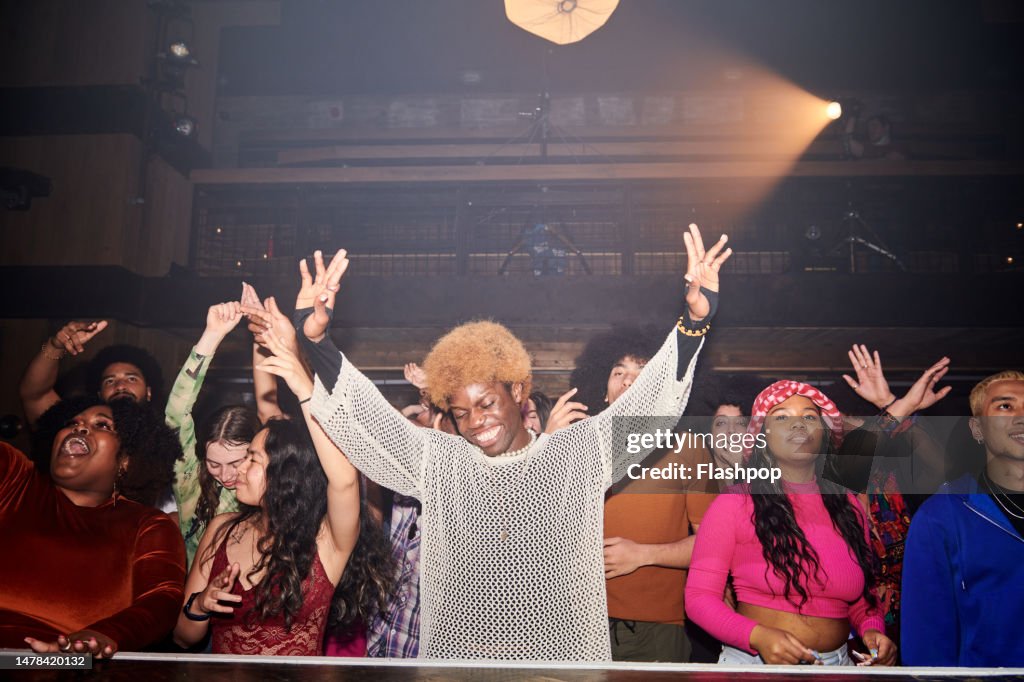 Group of people dancing at a music venue.