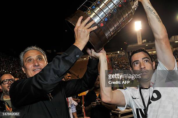 Coach Tite and Chicao of Brazil's Corinthians hold the Copa Libertadores trophy after their victory against Argentina's Boca Juniors during their...