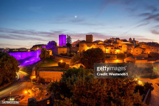 italy, lazio, tuscania, view of torre di lavello illuminated by purple light at dusk - viterbo foto e immagini stock
