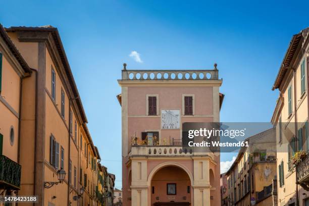 italy, lazio, tuscania, sundial on building standing between rows of town houses - provinsen viterbo bildbanksfoton och bilder