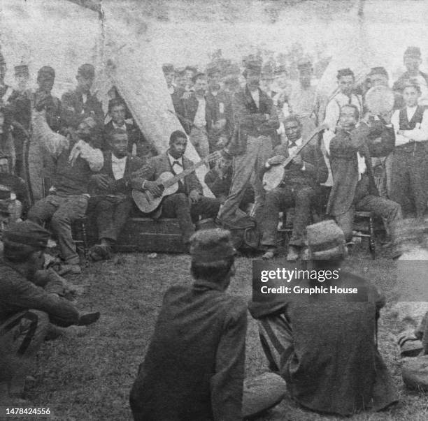 Musicians providing entertainment at an Union Army camp during the American Civil War, United States, circa 1863. The musicians are posed in a stance...