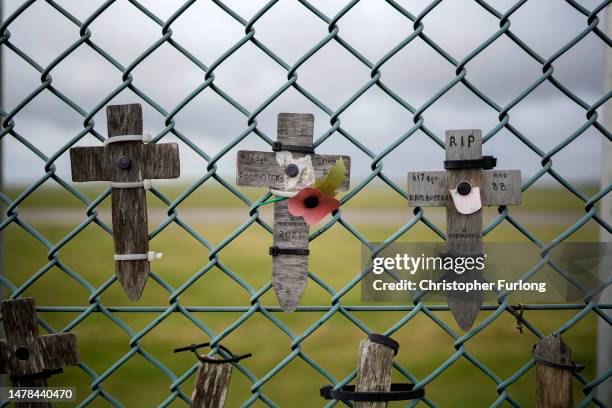 Crosses in remembrance of Dambusters aircrew are fixed to the fence of RAF Scampton on March 31, 2023 in Scampton, England. Minister for Immigration,...