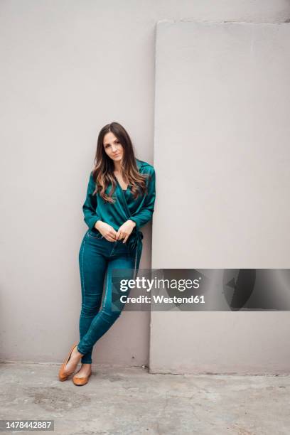 confident young businesswoman leaning by wall - leaning stock pictures, royalty-free photos & images