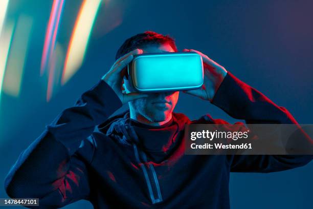 man wearing virtual reality simulators - réalité virtuelle photos et images de collection