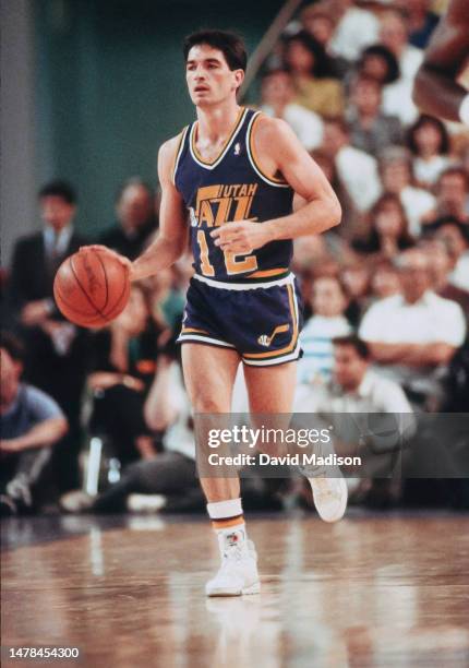 John Stockton of the Utah Jazz dribbles the ball during an NBA game against the Phoenix Suns played on April 9, 1990 at the Arizona Veterans Memorial...