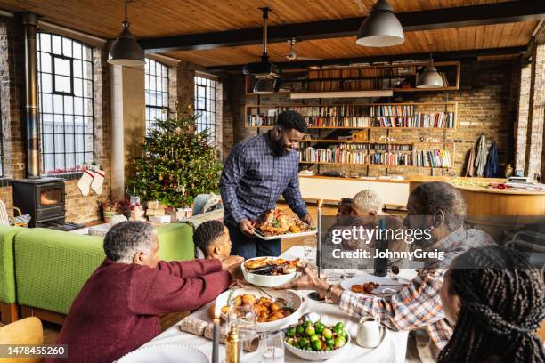 father bring roast turkey lunch table at christmas - big family dinner stock pictures, royalty-free photos & images