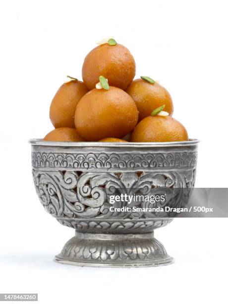 close-up of oranges in bowl against white background,romania - gulab jamun stock pictures, royalty-free photos & images