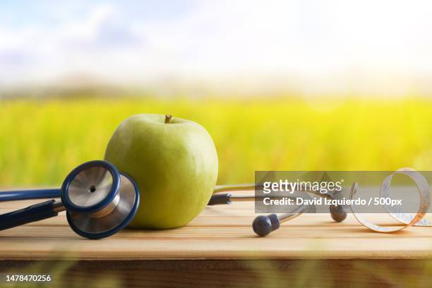 health concept with apple stethoscope and tape measure in nature,spain - caution tape stockfoto's en -beelden