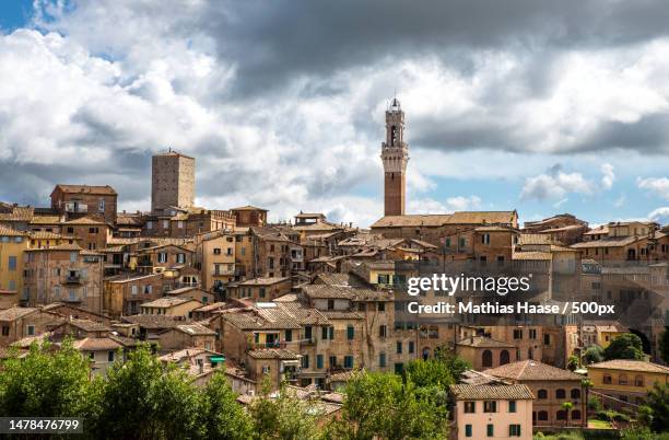 view of buildings in city against cloudy sky,siena,province of siena,italy - siena province - fotografias e filmes do acervo