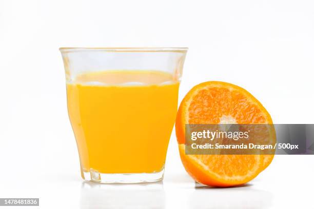 close-up of orange juice against white background,romania - orange juice glass white background stock-fotos und bilder