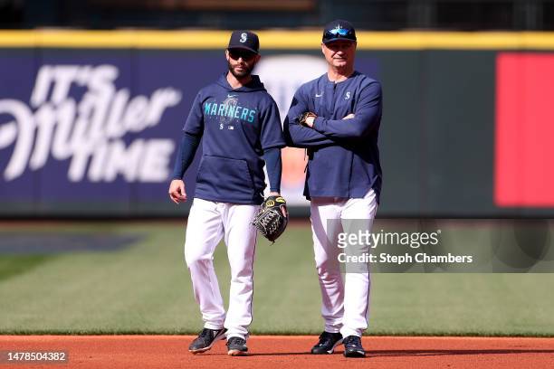 Tommy La Stella and manager Scott Servais of the Seattle Mariners talk during batting practice before the game against the Cleveland Guardians at...