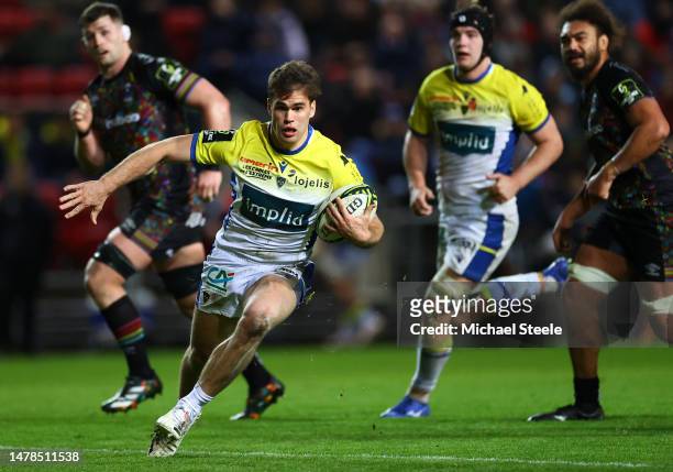 Damian Penaud of ASM Clermont Auvergne breaks through to score their side's second try during the EPCR Challenge Cup Round of Sixteen match between...