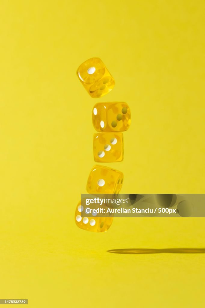 Falling yellow dices on yellow background,Romania