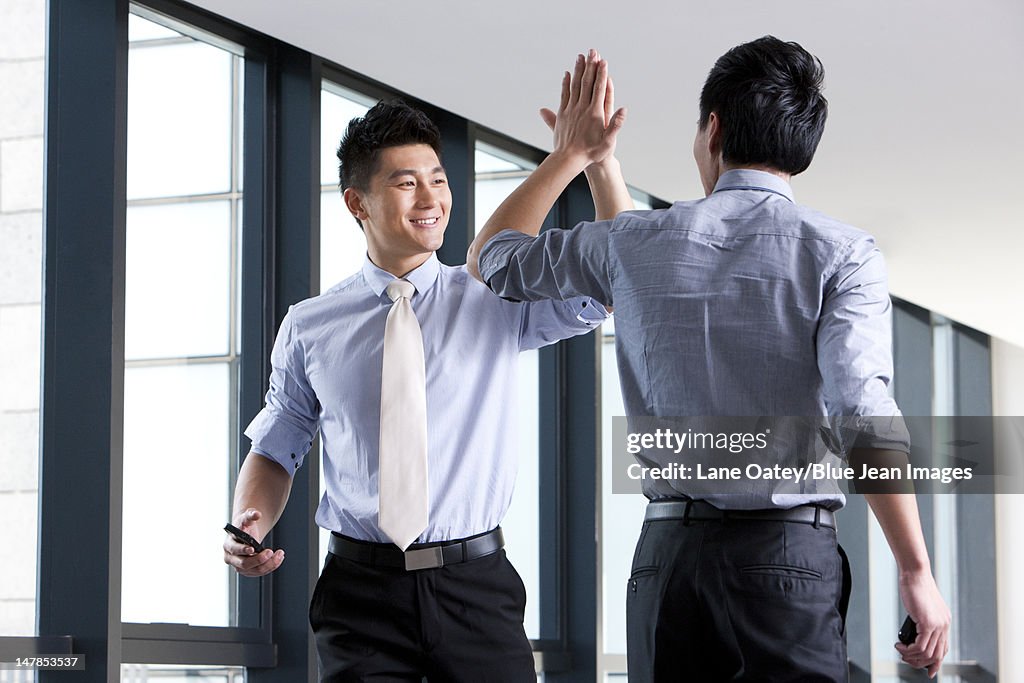 Businessmen high-fiving each other