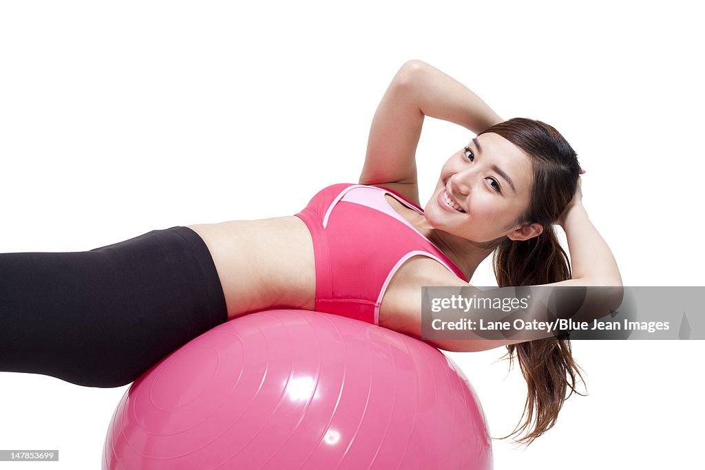 Young woman doing sit-ups on a fitness ball