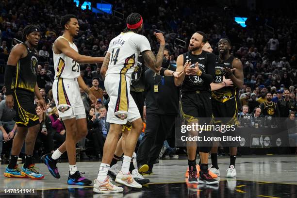 Stephen Curry and Draymond Green of the Golden State Warriors address Brandon Ingram of the New Orleans Pelicans following a scuffle during the...