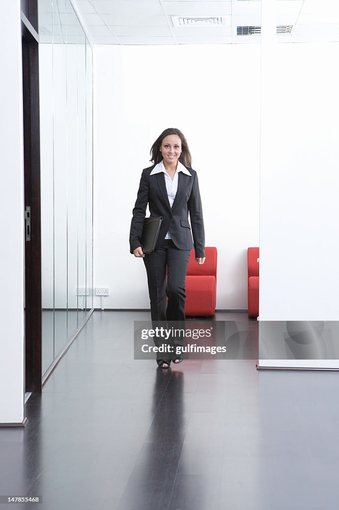 Businesswoman walking in the office hallway