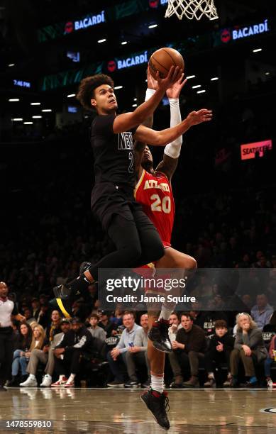 Cameron Johnson of the Brooklyn Nets scores on a fast break as Bruno Fernando of the Atlanta Hawks defends during the game at Barclays Center on...