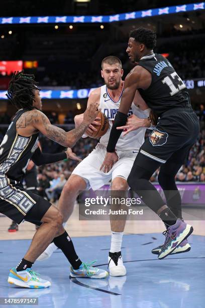 Ivica Zubac of the Los Angeles Clippers goes to the basket during the first half against Jaren Jackson Jr. #13 and Ja Morant of the Memphis Grizzlies...