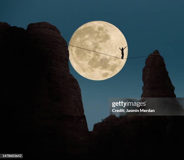 man walking on a rope - tightrope walking stock-fotos und bilder