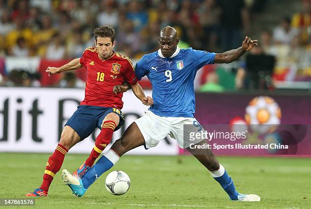 Mario Balotelli of Italy and Jordi Alba of Spain battle for the ball during the UEFA EURO 2012 final match between Spain and Italy at Olympic Stadium...