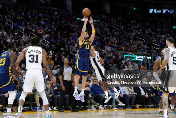 Klay Thompson of the Golden State Warriors shoots and makes a three-point shot over Tre Jones of the San Antonio Spurs during the fourth quarter at...