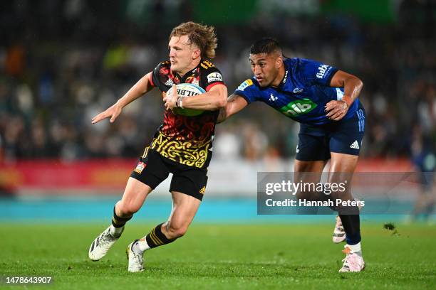 Damian McKenzie of the Chiefs gets past Rieko Ioane of the Blues during the round six Super Rugby Pacific match between Chiefs and Blues at FMG...