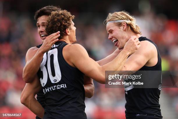 Charlie Curnow of the Blues celebrates with Jack Silvagni and Tom De Koning of the Blues after kicking a goal during the round three AFL match...