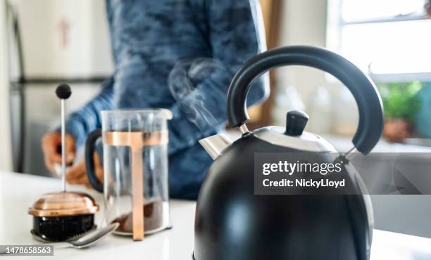 steaming kettle on stove in kitchen - boiling stock pictures, royalty-free photos & images