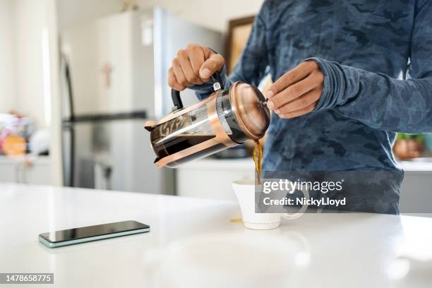 unrecognizable person making coffee for themself in kitchen - coffee plunger stock pictures, royalty-free photos & images