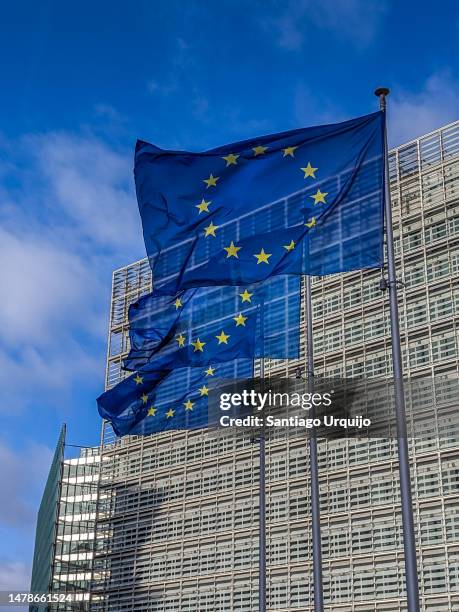 european union flags waving at berlaymont building of the european commission - vertical flag stock pictures, royalty-free photos & images