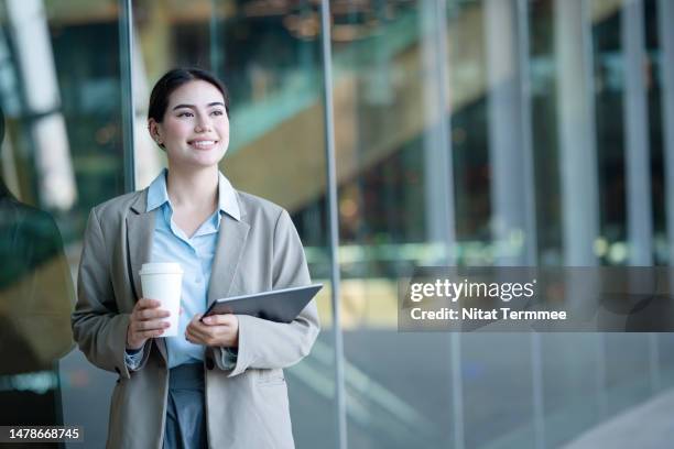 stability and growth with financial services for your business. portrait of a female financial advisor working in a modern business office holding a tablet computer and a coffee cup. - portrait solid stock pictures, royalty-free photos & images